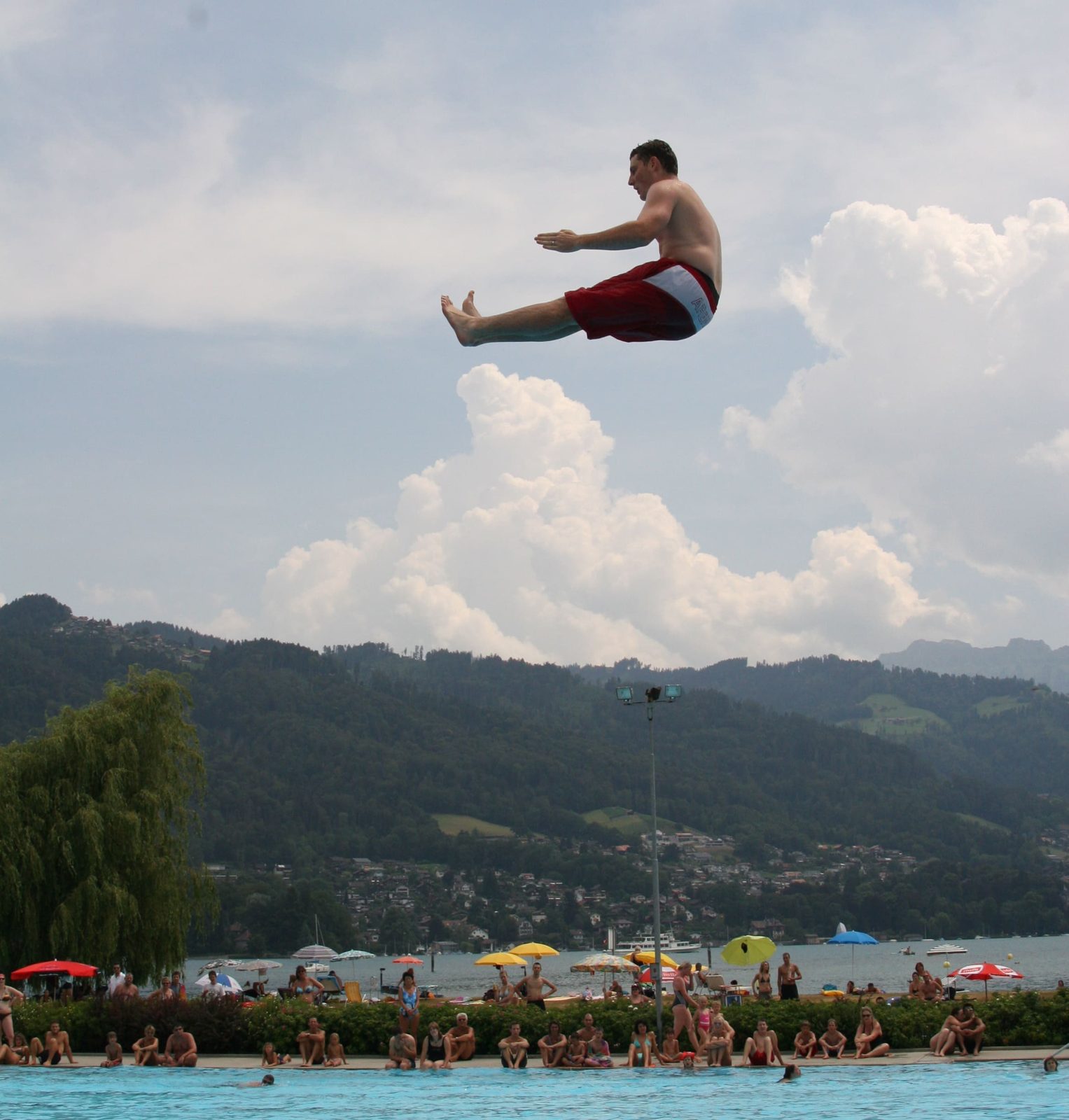Splashdiver in waagerechter Flugphase vor Bergen und Wolken