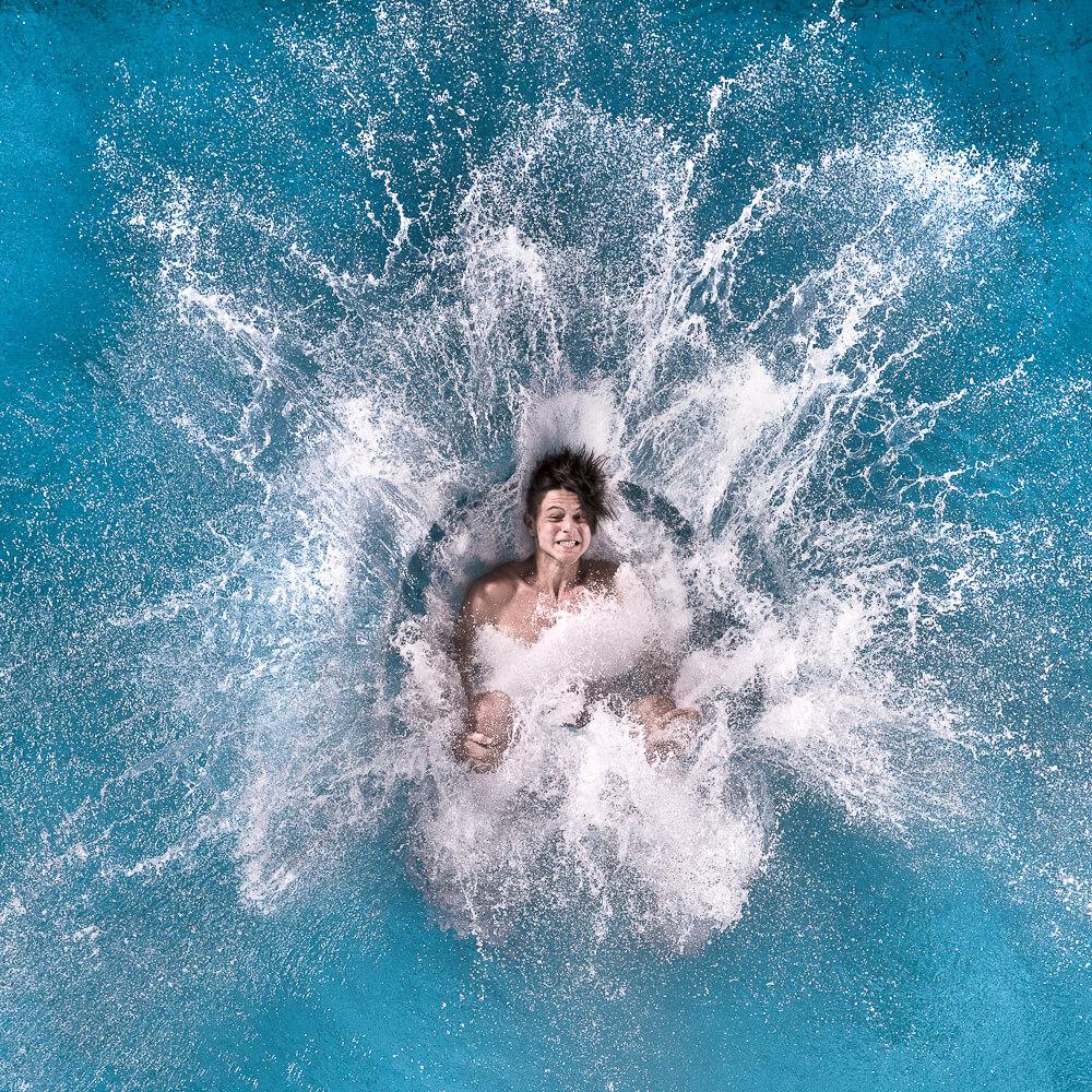 Splashdiver landet von oben gesehen im Wasser und erzeugt eine weiße Fontäne